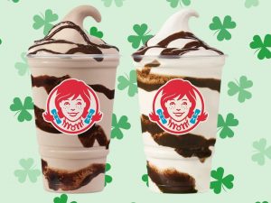 two wendy's frosty cups on a green shamrock background