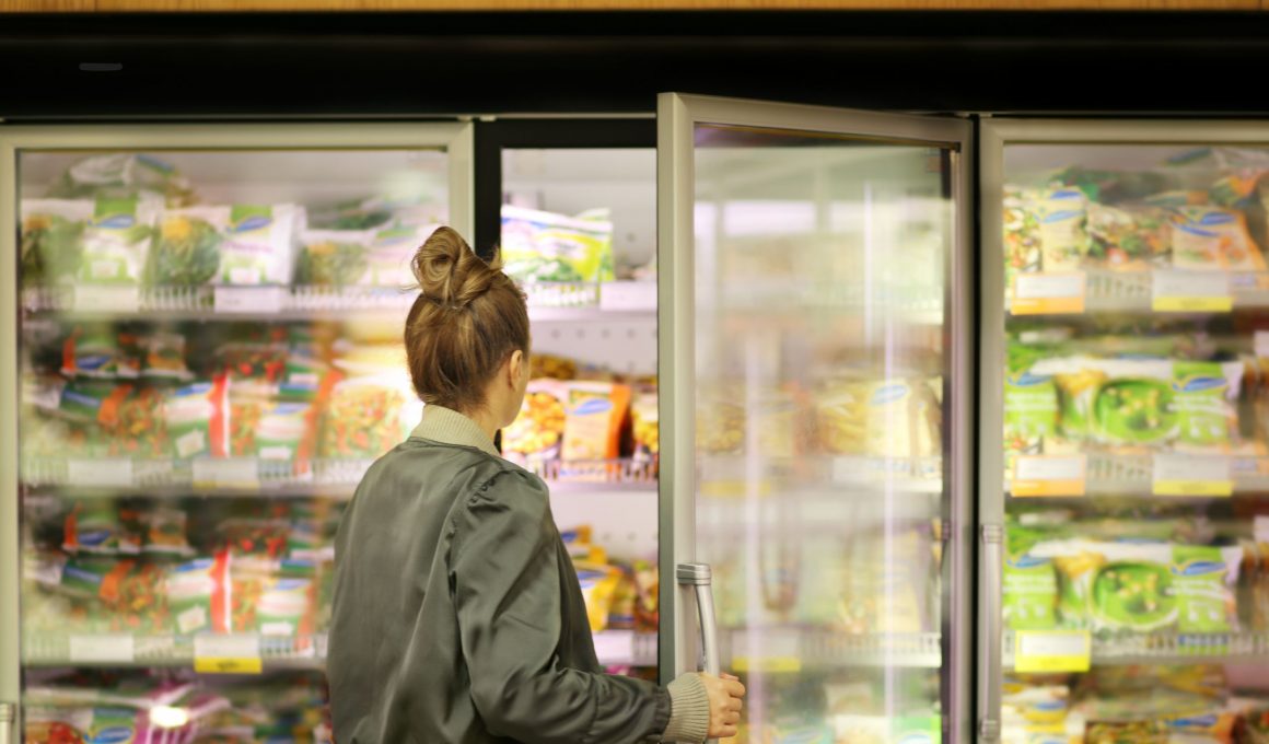 woman looking in a grocery freezer