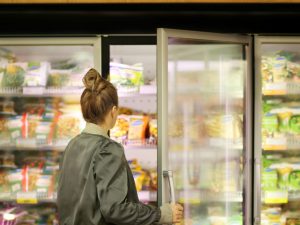 woman looking in a grocery freezer