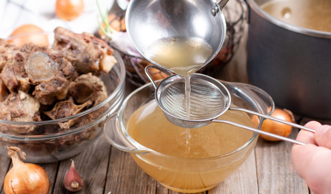 bone broth being poured into a cup